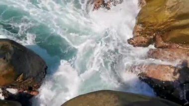 Plaj kumsalı turkuvaz mavi su kayaları kaya kayaları palmiye ağaçları büyük sörfçü dalgaları ve plaj manzarası Playa Manzanillo ve Puerto Angelito Puerto Escondido Oaxaca Meksika.