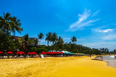 Mirissa Southern Eyaleti Sri Lanka 19. Mart 2018 Dalgalar, güneş şemsiyeleri ve Mirissa Sahili Sri Lanka 'da turistlerle dolu güzel bir tropikal plaj..