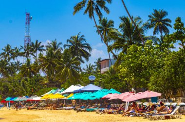 Mirissa Southern Eyaleti Sri Lanka 19. Mart 2018 Dalgalar, güneş şemsiyeleri ve Mirissa Sahili Sri Lanka 'da turistlerle dolu güzel bir tropikal plaj..