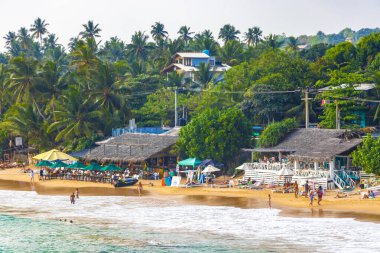 Mirissa Southern Eyaleti Sri Lanka 19. Mart 2018 Dalgalar, güneş şemsiyeleri ve Mirissa Sahili Sri Lanka 'da turistlerle dolu güzel bir tropikal plaj..
