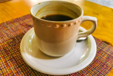 Playa del Carmen Quintana Roo Meksika 'daki restoran kafeteryasında bir bardak siyah kaşık ve tabak kahve..