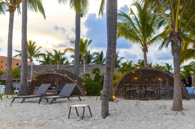 Palapa sazdan çatılar palmiye ağaçları şemsiyeler ve Playa del Carmen Meksika 'daki tropikal Meksika plajındaki sahil otelindeki güneş pansiyonları..