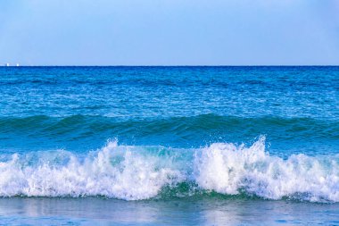 Dalgalar, Playa del Carmen Meksika 'daki tropik Meksika Karayip plajlarında mavi su ve kumsala vurur..