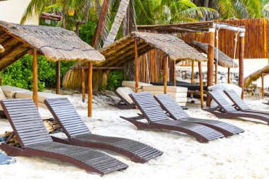 Palapa sazdan çatılar palmiye ağaçları şemsiyeler ve Playa del Carmen Meksika 'daki tropikal Meksika plajındaki sahil otelindeki güneş pansiyonları..