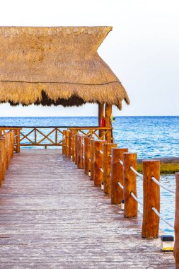 Punta 'da palapa bungalovu ve Playa Xcalacoco Playa del Carmen Mexico' da berrak turkuaz mavi su ve iskeleli tropik Meksika Karayip sahili manzarası..
