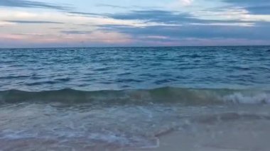 Playa del Carmen Mexico 'da turkuaz mavi su tatil beldeleri ve palmiye ağaçlarıyla tropikal Meksika Karayip Sahili manzarasında muhteşem ve renkli gün batımı..