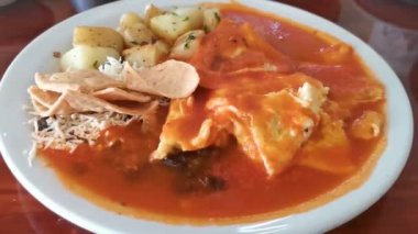 Meksika omleti ve siyah fasulyeli yumurta patates ve beyaz tabakta nachos Zicatela Puerto Oaxaca Meksika 'da El Cafecito' da..