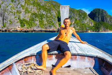 Turist gezgin erkek adam, Kireçtaşı kayaları ve temiz turkuaz mavi su Koh Phi Leh adası Ao Nang Krabi Tayland 'da uzun kuyruklu teknelerle selfie çekiyor..