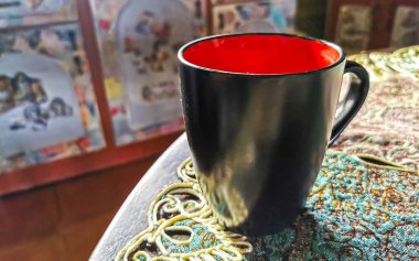 Orta Amerika 'da Para Heredia Kosta Rika' da zarif bir turkuaz masa örtüsünde kırmızı ve siyah kahve fincanı..