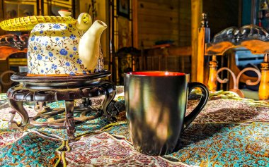 Orta Amerika 'da Para Heredia Kosta Rika' da zarif bir turkuaz masa örtüsünde kırmızı ve siyah kahve fincanı..