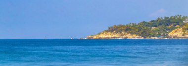 Güneş kumsalı insanları sörf yapıyor palmiye ağaçları turizm plaj barı ve Zicatela Puerto Escondido Oaxaca Meksika 'da mavi su dalgaları.