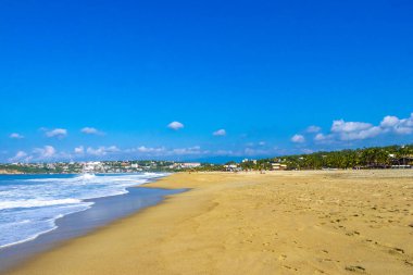 Güneş kumsalı insanları sörf yapıyor palmiye ağaçları turizm plaj barı ve Zicatela Puerto Escondido Oaxaca Meksika 'da mavi su dalgaları.