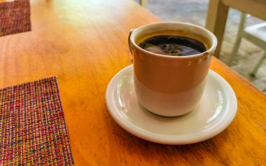 Playa del Carmen Quintana Roo Meksika 'daki restoran kafeteryasında bir bardak siyah kaşık ve tabak kahve..