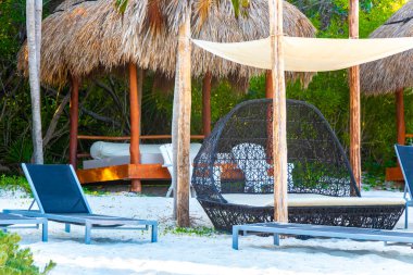 Palapa sazdan çatılar palmiye ağaçları şemsiyeler ve Playa del Carmen Meksika 'daki tropikal Meksika plajındaki sahil otelindeki güneş pansiyonları..