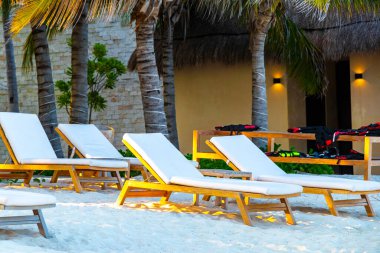 Palapa sazdan çatılar palmiye ağaçları şemsiyeler ve Playa del Carmen Meksika 'daki tropikal Meksika plajındaki sahil otelindeki güneş pansiyonları..