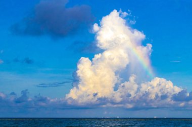 Playa del Carmen Meksika 'da berrak turkuaz mavi su ve bulutlarda inanılmaz gökkuşağı olan tropik Meksika Karayip plajı manzarası..