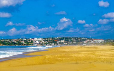 Puerto Escondido Oaxaca Meksika 13. Kasım 2022 'de güneş kumsalı insanları sörf yapıyor Palmiye ağaçları, plaj barı ve Zicatela Puerto Escondido Oaxaca' da mavi su dalgaları..