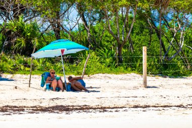 Playa del Carmen Quintana Roo Mexico 09. Eylül 2023 Tropikal Meksika Karayip plajı ve denizi çok eğlenceli insanlarla güneş şemsiyeleri Playa del Carmen Meksika 'da turkuaz su.