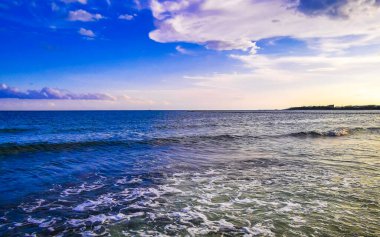 Playa del Carmen Mexico 'da turkuaz mavi su tatil beldeleri ve palmiye ağaçlarıyla tropikal Meksika Karayip Sahili manzarasında muhteşem ve renkli gün batımı..