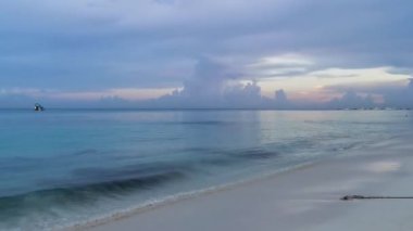 Playa del Carmen Mexico 'da turkuaz mavi su tatil beldeleri ve palmiye ağaçlarıyla tropikal Meksika Karayip Sahili manzarasında muhteşem ve renkli gün batımı..