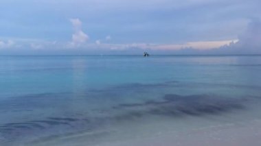 Playa del Carmen Mexico 'da turkuaz mavi su tatil beldeleri ve palmiye ağaçlarıyla tropikal Meksika Karayip Sahili manzarasında muhteşem ve renkli gün batımı..