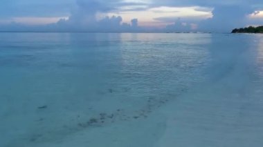 Playa del Carmen Mexico 'da turkuaz mavi su tatil beldeleri ve palmiye ağaçlarıyla tropikal Meksika Karayip Sahili manzarasında muhteşem ve renkli gün batımı..