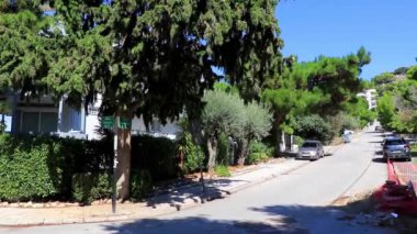 Voula Attica Yunanistan 06. Ekim 2018 Voula Attica Yunanistan 'daki Voula' da gün içinde binalar ve ağaçlar arasındaki Tipik cennet caddesi.