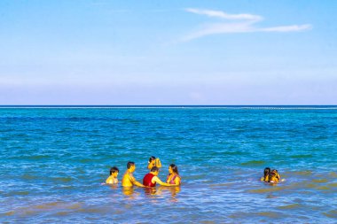 Playa del Carmen Quintana Roo Meksika 05. Ağustos 2023 Tropikal Meksika Karayip plajı ve denizi çok eğlenceli insanlarla güneş şemsiyeleri Playa del Carmen Meksika 'da turkuaz su.