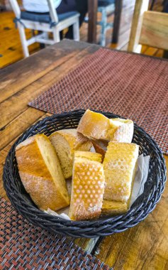 Playa del Carmen Quintana Roo Mexico 'daki PapaCharly Papa Charly restoranında tahtadan sofra yemeği ve içecek sepetinde ekmek..
