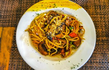 Playa del Carmen Quintana Roo Mexico 'daki PapaCharly Papa Charly restoranında beyaz tabak Tayland makarnası yemek ve içecek..