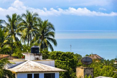 Beautiful tropical and natural city and seascape landscape panorama view with pacific ocean sea palms palm trees and beach with waves of Zicatela Puerto Escondido Oaxaca Mexico.