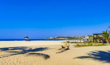 Sun beach sand people waves palms tourism and blue water in Zicatela Puerto Escondido Oaxaca Mexico.