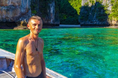 Turist gezgin erkek adam, Kireçtaşı kayaları ve temiz turkuaz mavi su Koh Phi Leh adası Ao Nang Krabi Tayland 'da uzun kuyruklu teknelerle selfie çekiyor..