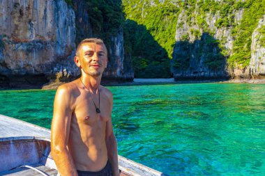 Turist gezgin erkek adam, Kireçtaşı kayaları ve temiz turkuaz mavi su Koh Phi Leh adası Ao Nang Krabi Tayland 'da uzun kuyruklu teknelerle selfie çekiyor..