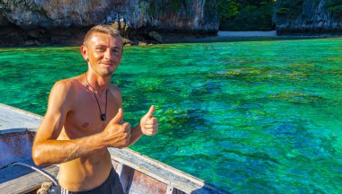 Turist gezgin erkek adam, Kireçtaşı kayaları ve temiz turkuaz mavi su Koh Phi Leh adası Ao Nang Krabi Tayland 'da uzun kuyruklu teknelerle selfie çekiyor..