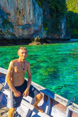 Turist gezgin erkek adam, Kireçtaşı kayaları ve temiz turkuaz mavi su Koh Phi Leh adası Ao Nang Krabi Tayland 'da uzun kuyruklu teknelerle selfie çekiyor..