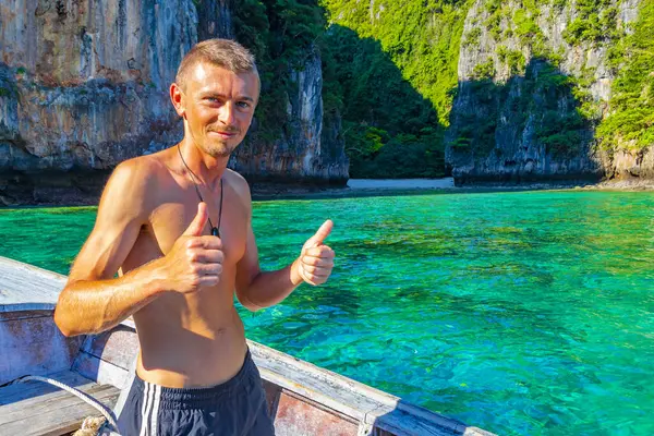 Turist gezgin erkek adam, Kireçtaşı kayaları ve temiz turkuaz mavi su Koh Phi Leh adası Ao Nang Krabi Tayland 'da uzun kuyruklu teknelerle selfie çekiyor..