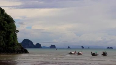 Turkuaz su sahilinin güzel tropik cennet manzarası uzun kuyruklu botlarla ve Ao Nang Krabi Tayland 'daki NopPharat Thara sahilindeki kireçtaşı kayaları arasında..