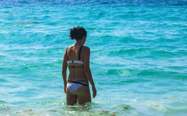 Seksi bayan güzel kadın model, tropikal Meksika sahillerindeki kumsalda ve Playa del Carmen Quintana Roo Mexico 'daki turkuaz berrak sularda poz veriyor..