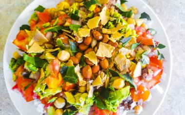 Vegetable dish soup with beans peas potatoes onions tomato and garlic on a white plate bowl with fork or spoon in Mexico.