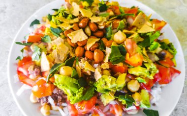 Vegetable dish soup with beans peas potatoes onions tomato and garlic on a white plate bowl with fork or spoon in Mexico.