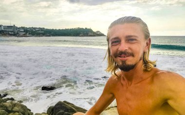 Erkek turist güzel kayalıklarla selfie çekiyor kayalar kayalar kayalar, büyük sörfçü dalgaları ve Puerto Escondido Oaxaca 'da doğal manzara..