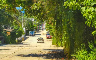 Puerto Escondido Oaxaca Meksika 03. Ekim 2022 Tipik güzel turistik cadde yolu ve şehir arabalarıyla kaldırım oteller, restoranlar ve Zicatela Mexico 'daki insanlar..