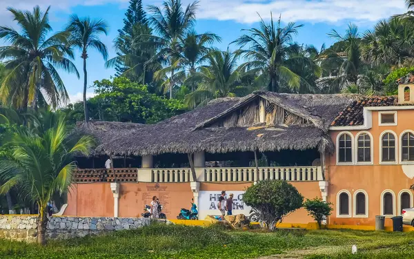 Puerto Escondido Oaxaca Meksika 12. Ocak 2023 Tipik güzel turist caddesi yolu ve şehir arabalarıyla kaldırım oteller, restoranlar ve Zicatela Mexico 'daki insanlar..