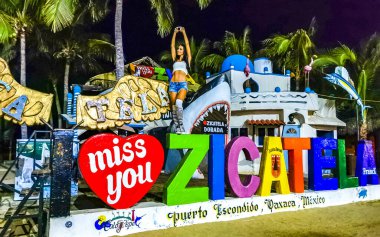 Zicatela Puerto Escondido 'nun Zicatela Puerto Oaxaca' daki plajdaki işaret sembolü renkli Zicatela Puerto Escondido 'da güzel bir kadın ve turist..