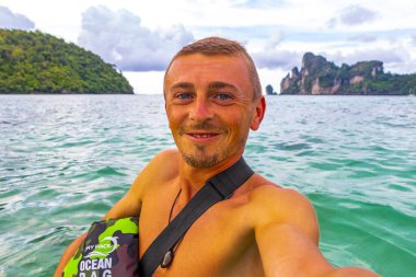 Erkek turist, Güneydoğu Asya 'daki Ao Nang Amphoe Mueang Krabi Tayland' daki Koh Phi Phi Don adasında tropikal plajda selfie çekiyor..
