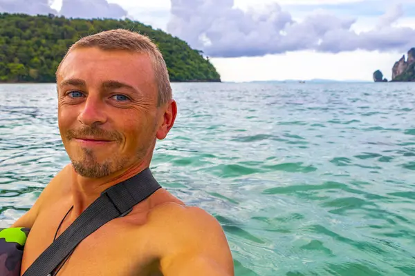 Erkek turist, Güneydoğu Asya 'daki Ao Nang Amphoe Mueang Krabi Tayland' daki Koh Phi Phi Don adasında tropikal plajda selfie çekiyor..