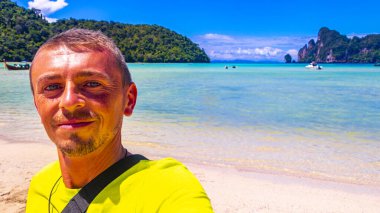 Erkek turist, Güneydoğu Asya 'daki Ao Nang Amphoe Mueang Krabi Tayland' daki Koh Phi Phi Don adasında tropikal plajda selfie çekiyor..