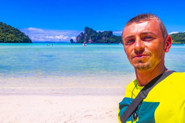 Erkek turist, Güneydoğu Asya 'daki Ao Nang Amphoe Mueang Krabi Tayland' daki Koh Phi Phi Don adasında tropikal plajda selfie çekiyor..