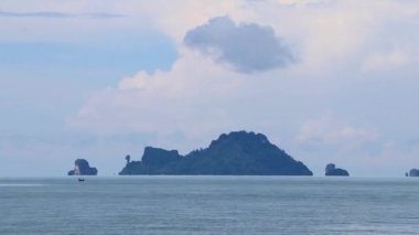 Turkuaz su plajındaki feribot manzaralı tropik cennet manzarası ve Amphoe Mueang Krabi Tayland 'daki Ao Nang Sahili' ndeki kireçtaşı tepeleri ve dağlar arasındaki uçurum..